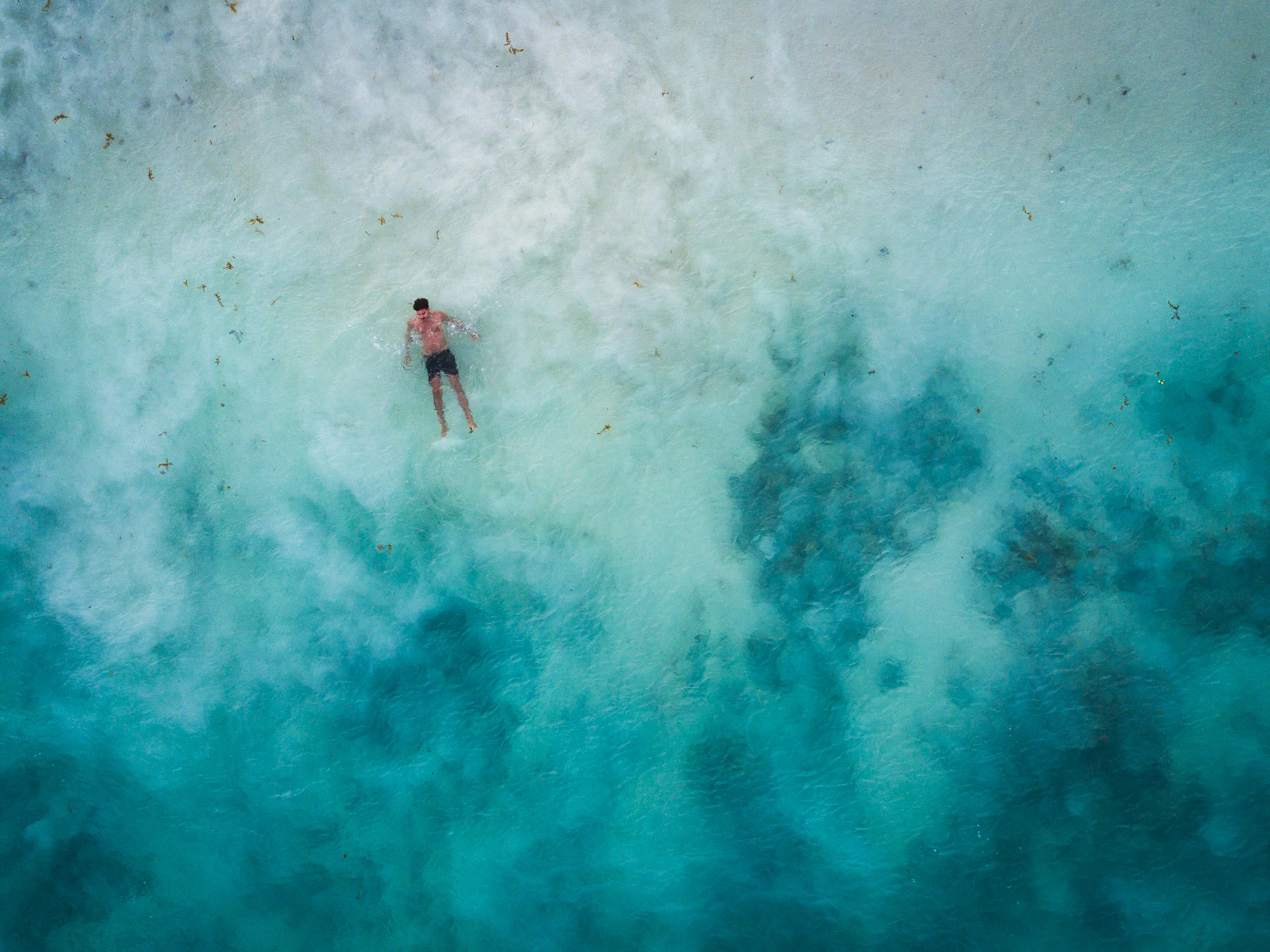 high-angle photography of man in body of water